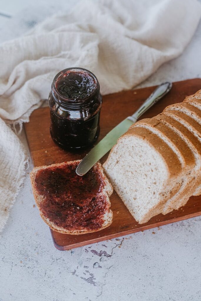 Sliced white bread with berry jam spread, captured as a cozy breakfast scene.