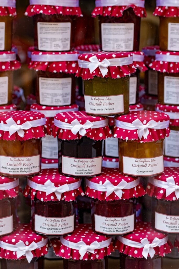 Colorful display of gourmet jam jars with decorative polka dot covers, perfect for artisanal food markets.