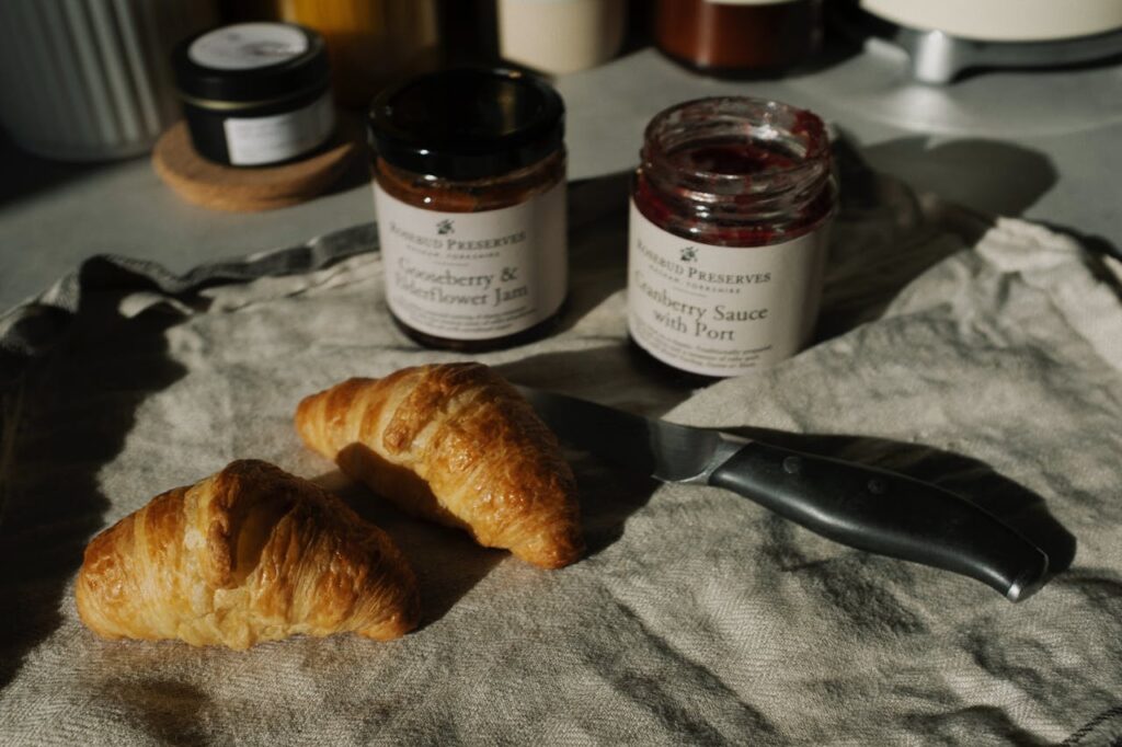 Tasty croissants with gooseberry jam and cranberry sauce for a delightful breakfast.